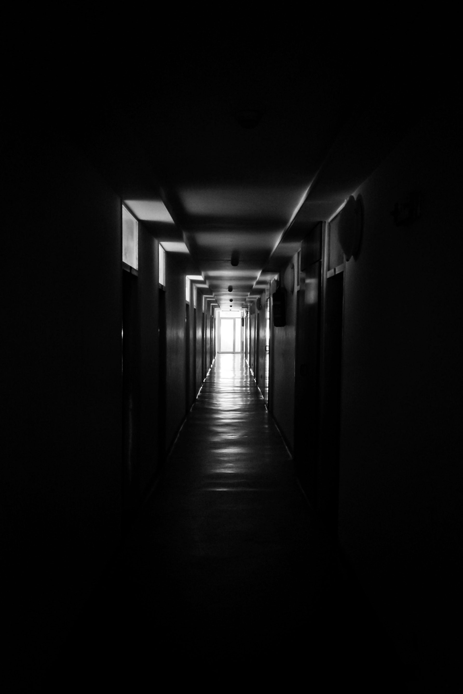 A long hallway with a light at the end of it