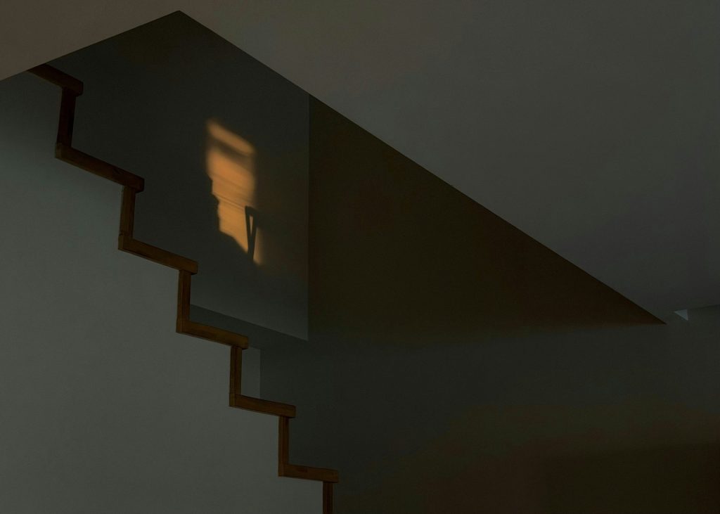 Sunlight reflects on a wall near stairs.